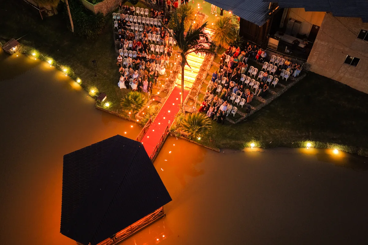 Escadaria iluminada à noite à beira do lago, durante uma cerimônia
